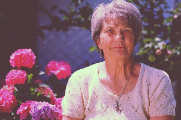 mujer con flores detras