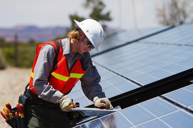 trabajador instalando placa solar